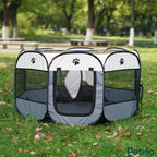 Beige and gray Petifo portable pet playpen set up outdoors on a green grass lawn with trees in the background.