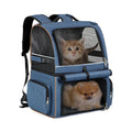 Blue denim-style double-compartment pet carrier backpack holding a cat on top and a small dog below.
