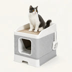A cat resting on the integrated top scratching pad of a Petifo quilted grey cat litter box.
