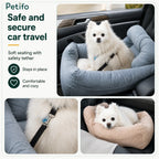 White fluffy dog sitting in a plush grey car booster seat featuring a secure safety tether and cozy interior cushions.