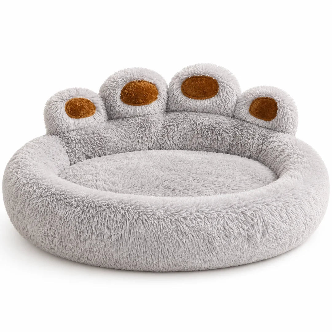 A fluffy gray dog bed shaped like a giant paw with brown accent pads on a white background.