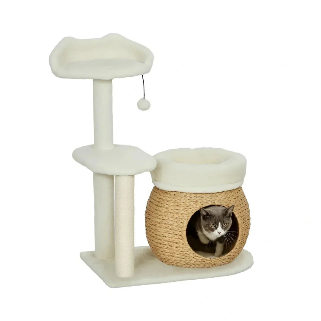 Gray and white cat sitting inside the woven basket hideaway of a multi-level white cat tree.