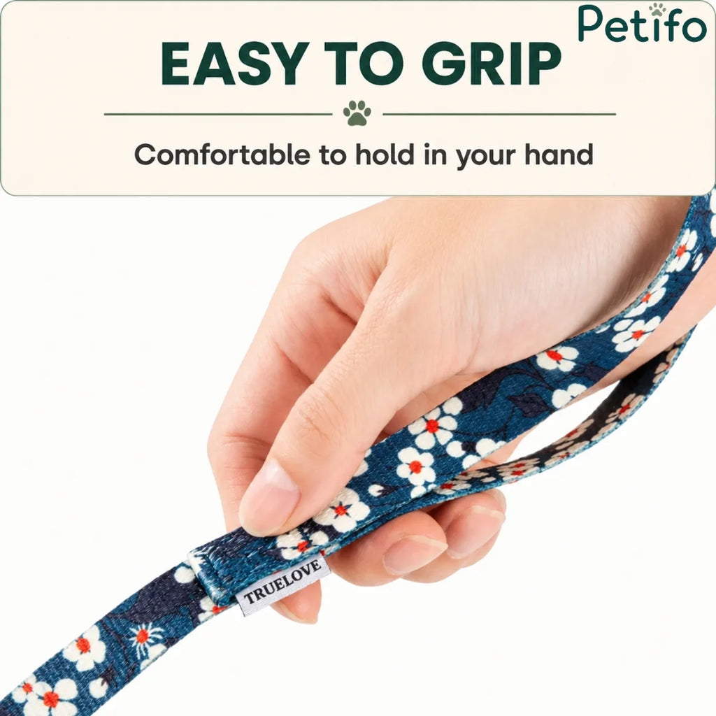 Hand holding the comfortable loop handle of a blue floral pattern dog leash.